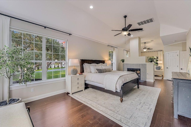 22 Wingreen Loop, The Hills, TX 78738 - bedroom featuring baseboards, dark wood-type flooring, a tiled fireplace, lofted ceiling, and recessed lighting