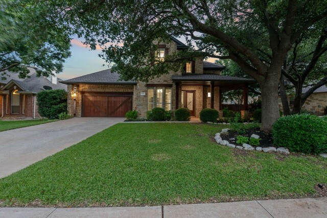3022 Luminoso Ln E, Round Rock, TX 78681 - view of front of house featuring a front yard, an attached garage, driveway, brick siding, and a porch