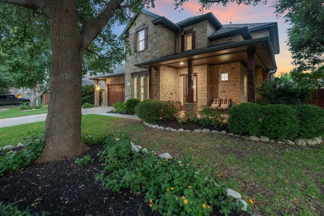 3022 Luminoso Ln E, Round Rock, TX 78681 - traditional home featuring stone siding, driveway, covered porch, a garage, and a lawn