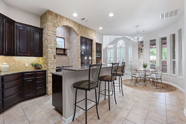 3022 Luminoso Ln E, Round Rock, TX 78681 - kitchen featuring light stone countertops, light tile patterned flooring, a breakfast bar area, oven, and recessed lighting