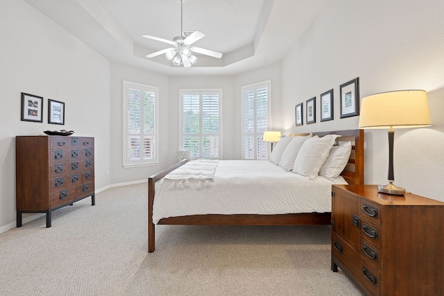 3022 Luminoso Ln E, Round Rock, TX 78681 - bedroom with a tray ceiling, light carpet, baseboards, and a ceiling fan