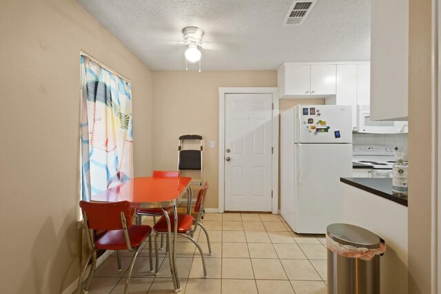 801 Terrell Hill Dr, Austin, TX 78704 - dining space featuring light tile patterned flooring, a textured ceiling, a ceiling fan, and baseboards