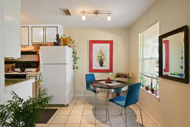 801 Terrell Hill Dr, Austin, TX 78704 - dining space with light tile patterned flooring, a textured ceiling, and baseboards