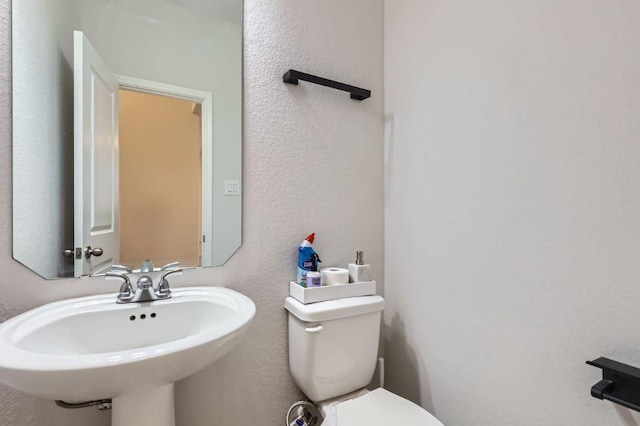 149 Woods Edge Ln, Georgetown, TX 78628 - half bath featuring toilet, a textured wall, and a sink