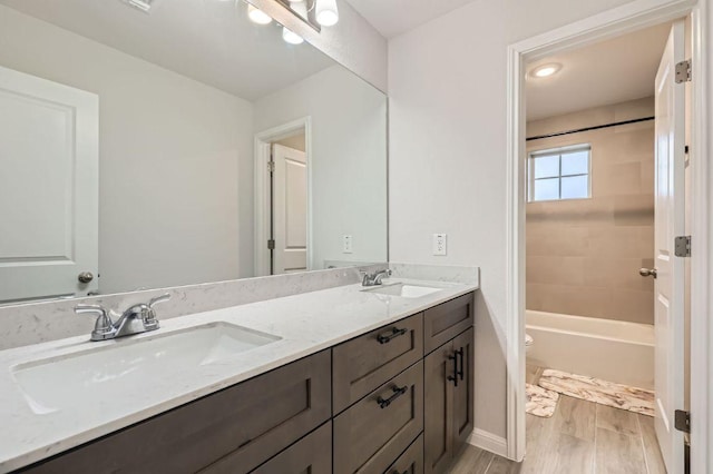 149 Woods Edge Ln, Georgetown, TX 78628 - full bathroom with double vanity, toilet, wood finished floors, baseboards, and bathtub / shower combination