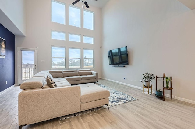 149 Woods Edge Ln, Georgetown, TX 78628 - living area with a ceiling fan, light wood-style floors, a high ceiling, and baseboards
