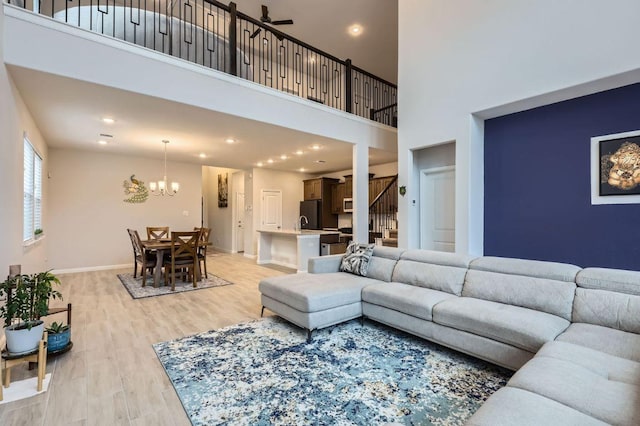 149 Woods Edge Ln, Georgetown, TX 78628 - living room with light wood finished floors, stairs, a chandelier, a high ceiling, and recessed lighting