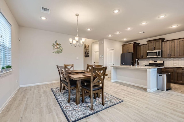 149 Woods Edge Ln, Georgetown, TX 78628 - dining area with a chandelier, light wood-type flooring, baseboards, and recessed lighting