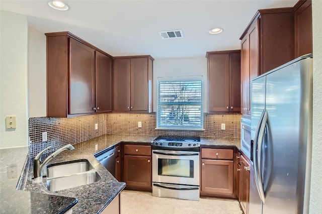 9707 Anderson Mill Rd Unit 32, Austin, TX 78750 - kitchen with appliances with stainless steel finishes, a sink, dark stone countertops, decorative backsplash, and recessed lighting