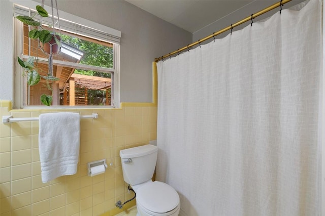 1308 Berkshire Dr, Austin, TX 78723 - bathroom with toilet, tile walls, a wainscoted wall, and a shower with shower curtain