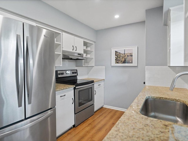 2600 Cockburn Dr, Austin, TX 78745 - kitchen with appliances with stainless steel finishes, open shelves, under cabinet range hood, decorative backsplash, and white cabinetry