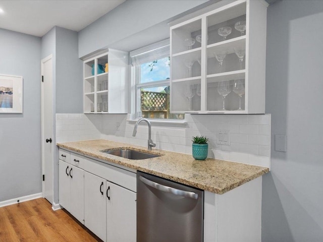 2600 Cockburn Dr, Austin, TX 78745 - kitchen featuring dishwasher, decorative backsplash, white cabinetry, light wood finished floors, and light stone countertops