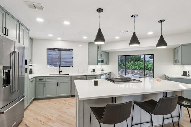 3902 Knollwood Dr Unit A, Austin, TX 78731 - kitchen featuring stainless steel appliances, a sink, light wood-type flooring, a center island, and backsplash