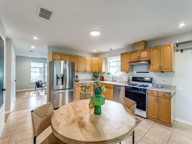 1705 Adriane Dr, Austin, TX 78721 - kitchen with stainless steel appliances, under cabinet range hood, light tile patterned floors, light countertops, and recessed lighting