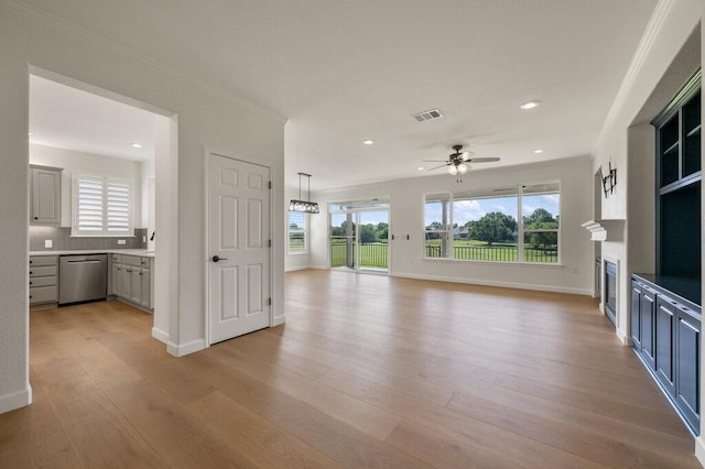 110 Chuckwagon Trl, Georgetown, TX 78633 - unfurnished living room with ceiling fan, plenty of natural light, ornamental molding, a glass covered fireplace, and recessed lighting