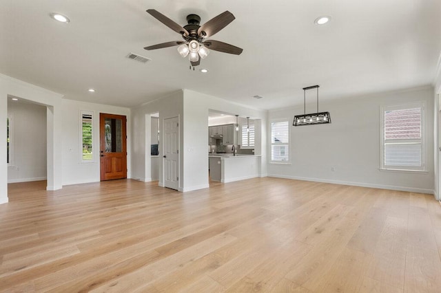 110 Chuckwagon Trl, Georgetown, TX 78633 - unfurnished living room with plenty of natural light, a ceiling fan, light wood-style flooring, recessed lighting, and ornamental molding