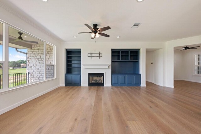 110 Chuckwagon Trl, Georgetown, TX 78633 - unfurnished living room featuring a ceiling fan, crown molding, a fireplace, baseboards, and light wood-style floors