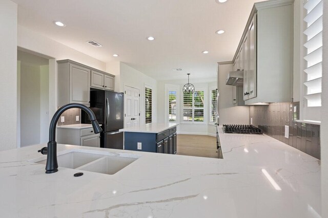 110 Chuckwagon Trl, Georgetown, TX 78633 - kitchen featuring gray cabinets, exhaust hood, a sink, recessed lighting, and backsplash