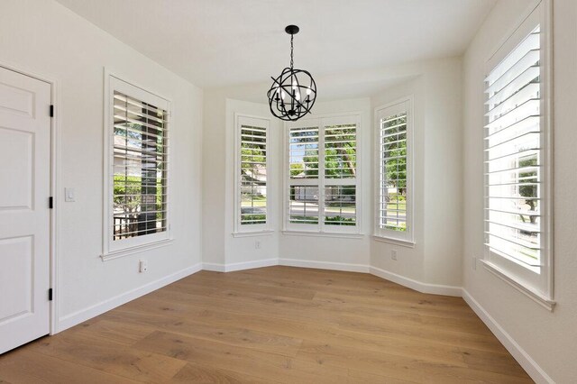 110 Chuckwagon Trl, Georgetown, TX 78633 - unfurnished dining area featuring a chandelier, plenty of natural light, and light wood-type flooring