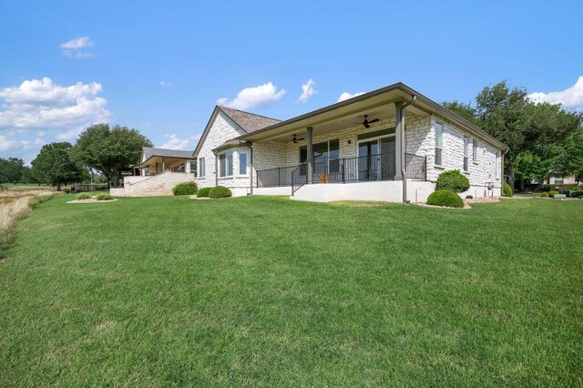 110 Chuckwagon Trl, Georgetown, TX 78633 - back of house with ceiling fan, stone siding, and a yard