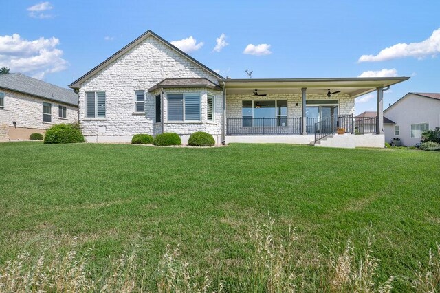 110 Chuckwagon Trl, Georgetown, TX 78633 - back of house featuring a ceiling fan, a yard, and stone siding
