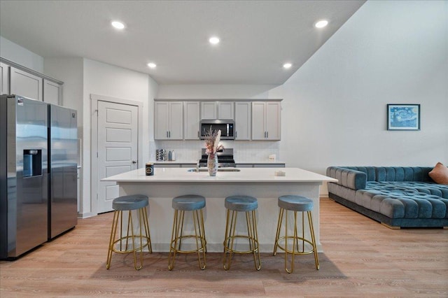 13705 Mc Arthur Dr, Manor, TX 78653 - kitchen with appliances with stainless steel finishes, gray cabinets, light wood-style flooring, tasteful backsplash, and a sink