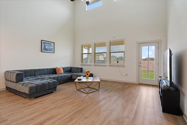 13705 Mc Arthur Dr, Manor, TX 78653 - living area with healthy amount of natural light, light wood-type flooring, a high ceiling, and baseboards