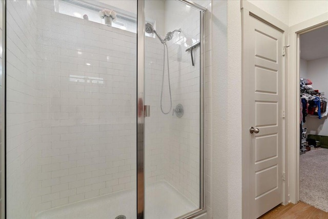 13705 Mc Arthur Dr, Manor, TX 78653 - full bathroom featuring a shower stall, wood finished floors, and a spacious closet