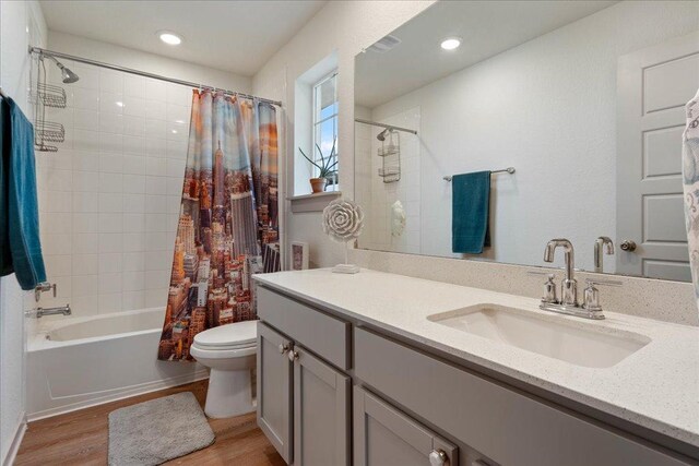 13705 Mc Arthur Dr, Manor, TX 78653 - bathroom featuring wood finished floors, toilet, shower / tub combo with curtain, vanity, and recessed lighting