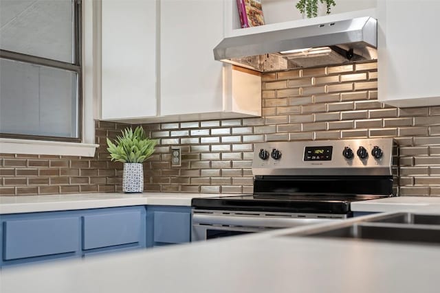 8617 Putnam Dr Unit C, Austin, TX 78757 - kitchen view of under cabinet range hood, electric range, light countertops, decorative backsplash, and blue cabinetry