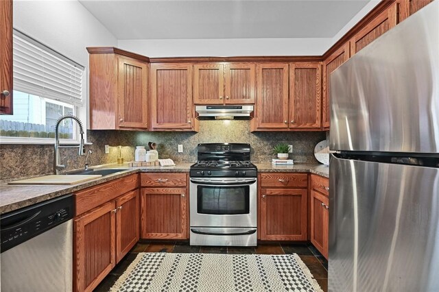 1169 Curve St, Austin, TX 78702 - kitchen featuring stainless steel appliances, under cabinet range hood, decorative backsplash, a sink, and brown cabinets