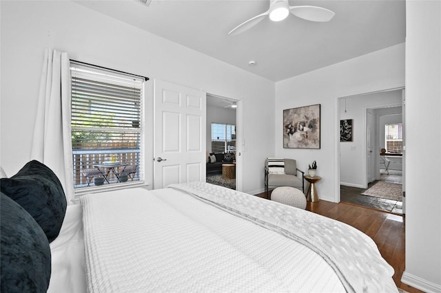 1169 Curve St, Austin, TX 78702 - bedroom with wood finished floors, multiple windows, baseboards, and a ceiling fan