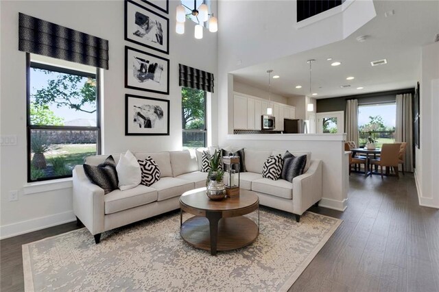 12109 Maypole Bnd, Austin, TX 78717 - living room with healthy amount of natural light, dark wood-type flooring, baseboards, a high ceiling, and recessed lighting