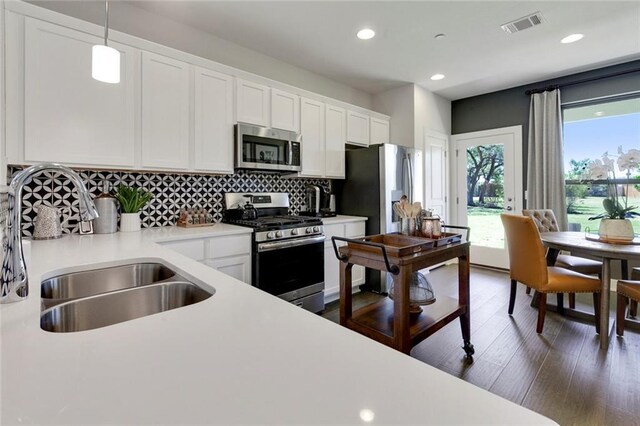 12109 Maypole Bnd, Austin, TX 78717 - kitchen with stainless steel appliances, a sink, light countertops, white cabinets, and decorative backsplash