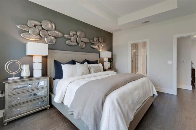 12109 Maypole Bnd, Austin, TX 78717 - bedroom with dark wood finished floors, baseboards, a tray ceiling, and ensuite bath