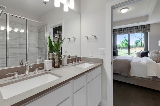 12109 Maypole Bnd, Austin, TX 78717 - ensuite bathroom with double vanity, a stall shower, and wood finished floors