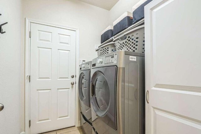 340 Beretta Cir, Georgetown, TX 78628 - laundry room with washer and clothes dryer and light tile patterned flooring