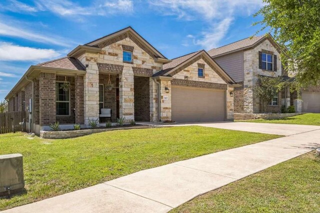 340 Beretta Cir, Georgetown, TX 78628 - french country style house featuring stone siding, a front lawn, concrete driveway, and a garage