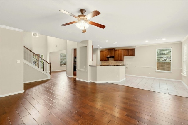 7420 Jaborandi Dr, Austin, TX 78739 - unfurnished living room featuring a ceiling fan, baseboards, wood finished floors, crown molding, and stairway