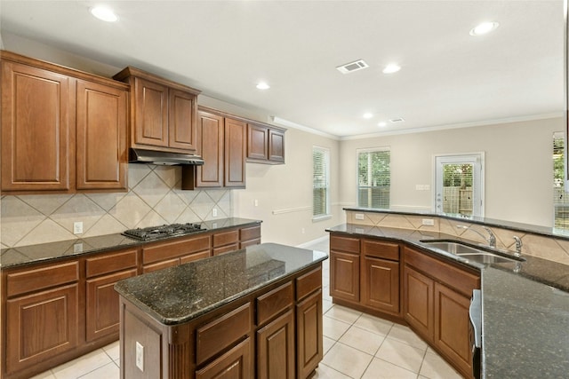7420 Jaborandi Dr, Austin, TX 78739 - kitchen with stainless steel gas stovetop, a sink, under cabinet range hood, crown molding, and light tile patterned floors