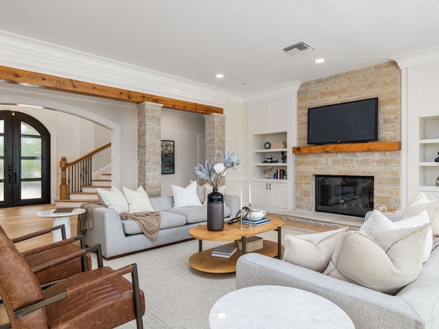 15902 Soleil Ct, Austin, TX 78734 - living room featuring built in features, french doors, crown molding, a stone fireplace, and stairs