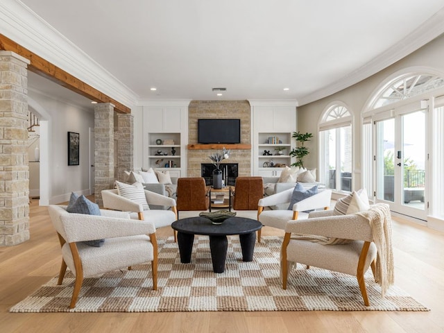 15902 Soleil Ct, Austin, TX 78734 - living room with decorative columns, a fireplace, ornamental molding, built in shelves, and light wood-type flooring