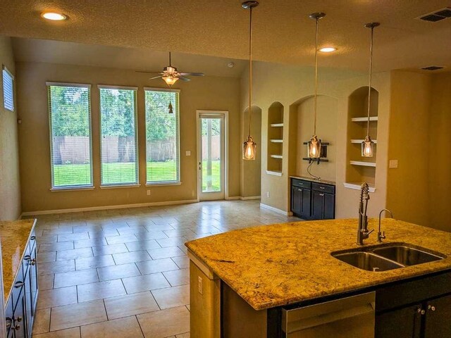 1226 Hidden Cave Dr, New Braunfels, TX 78132 - kitchen with a sink, built in features, open floor plan, baseboards, and a textured ceiling