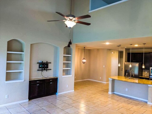 1226 Hidden Cave Dr, New Braunfels, TX 78132 - kitchen with built in shelves, a towering ceiling, stainless steel fridge, a ceiling fan, and a sink