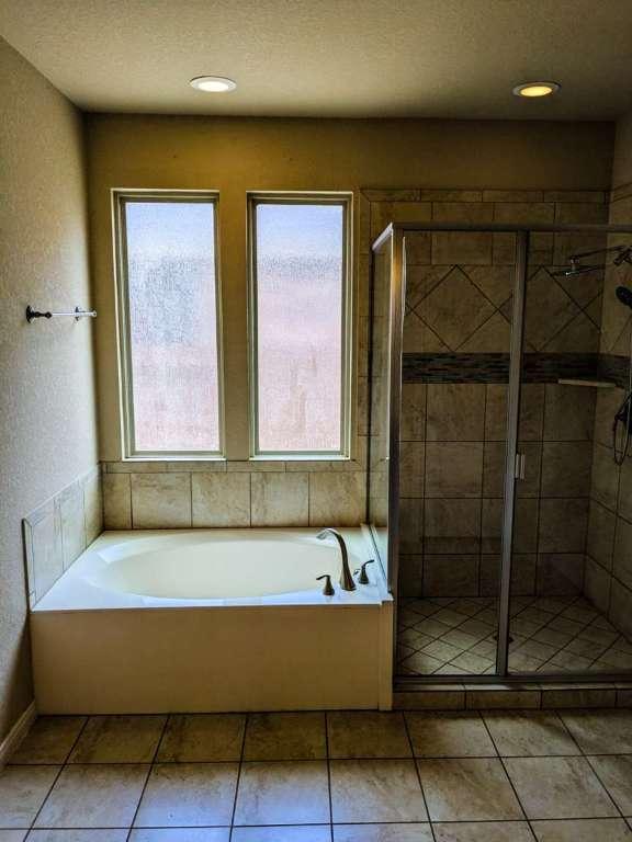 1226 Hidden Cave Dr, New Braunfels, TX 78132 - full bathroom featuring healthy amount of natural light, a garden tub, a shower stall, recessed lighting, and tile patterned floors