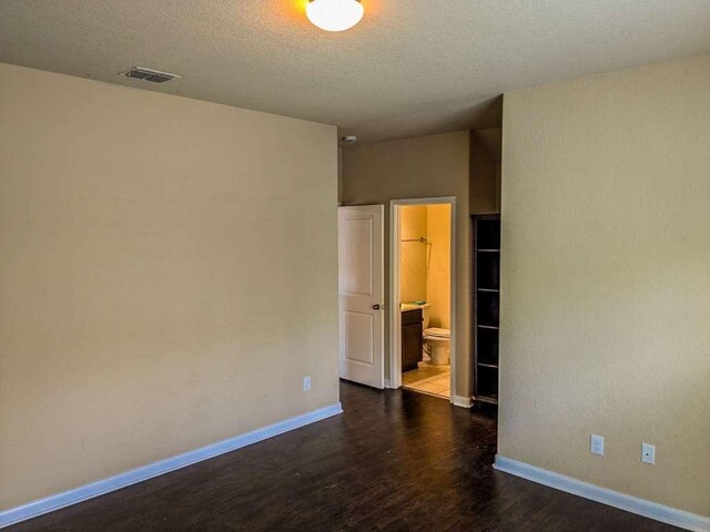 1226 Hidden Cave Dr, New Braunfels, TX 78132 - spare room featuring dark wood-style flooring, baseboards, and a textured ceiling