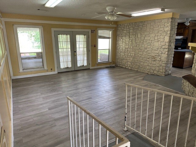 1412 Ocotilla Dr, Marble Falls, TX 78654 - unfurnished living room with ceiling fan, plenty of natural light, french doors, and wood finished floors