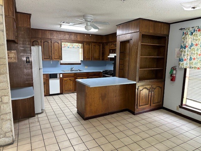1412 Ocotilla Dr, Marble Falls, TX 78654 - kitchen with a peninsula, a sink, white appliances, light countertops, and a ceiling fan