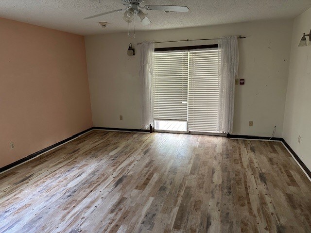 1412 Ocotilla Dr, Marble Falls, TX 78654 - unfurnished room with ceiling fan, wood finished floors, a textured ceiling, and baseboards