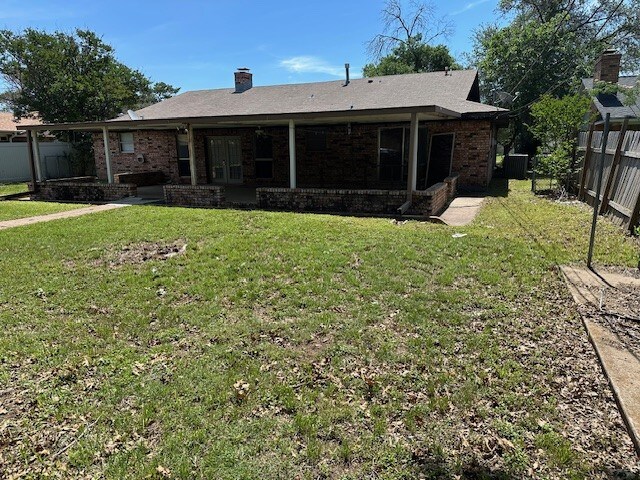 1412 Ocotilla Dr, Marble Falls, TX 78654 - rear view of property featuring brick siding and a chimney